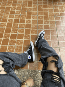 a person wearing a pair of black converse shoes