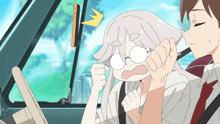 a man and a woman are sitting in a car and the woman has glasses on