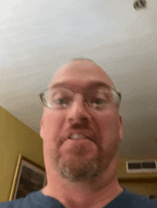 a man wearing glasses is making a funny face