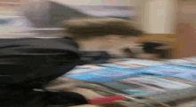 a blurred image of a person holding a stack of magazines with one that says ' a few ' on it