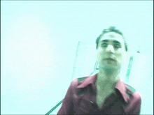 a man in a red shirt is walking through a hallway