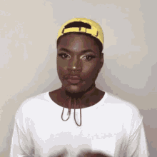 a man wearing a yellow hat and a white shirt .