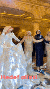 a group of women are dancing in a room with the words hedef ailesi written on the bottom
