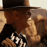 a man wearing a cowboy hat is holding a gun