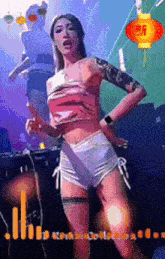 a woman in a pink top and white shorts is dancing on stage
