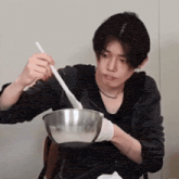 a man is mixing something in a bowl with a spatula