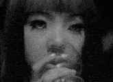 a black and white photo of a woman holding a glass