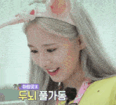 a woman wearing a headband with bunny ears is smiling with a foreign language written below her