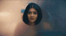 a close up of a woman 's face behind a glass wall .