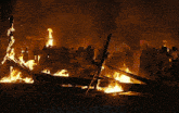 a group of people standing around a large fire