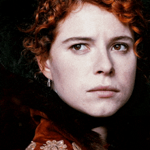 a close up of a woman 's face with a serious look on her face