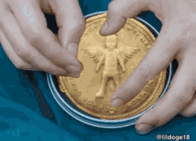 a close up of a person holding a gold coin with a picture of a person on it