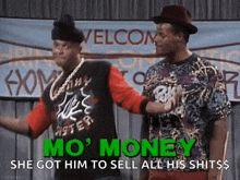 two men are standing next to each other on a stage in front of a sign .