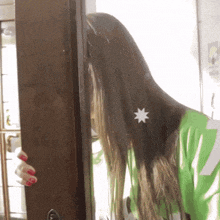 a woman with long hair is standing in front of a door with a star on her hair