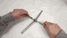 a person in a grey sweater is playing with a magnetic toy