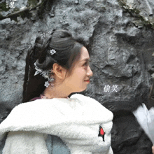 a woman wearing a white jacket with chinese writing on the back is smiling