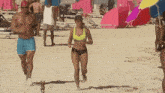 a group of people walking on a beach with umbrellas