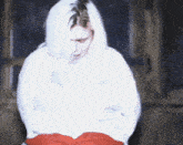 a woman with white hair is wearing a white sweater