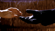 a man and a woman are reaching out to touch each other 's hands