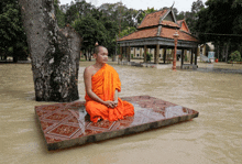 a monk sits on a raft in the water