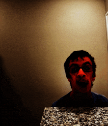 a man with glasses is looking at himself in a mirror