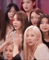 a group of young women are standing next to each other in a room and looking at the camera .