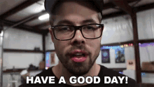 a man with glasses and a beard is saying have a good day