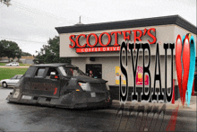 scooter 's coffee drive has a dominator car parked outside