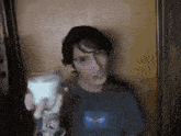 a man is holding a light bulb in his hand in front of a wall .