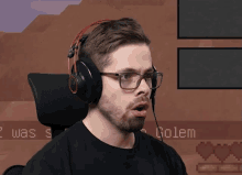 a man wearing glasses and headphones looks surprised in front of a screen that says " golem "