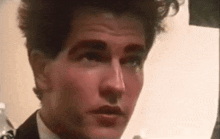 a close up of a man in a suit and tie making a funny face .