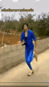 a man in a blue suit is running down a street in a video .