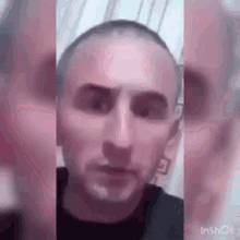 a close up of a man 's face with a shaved head .