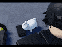 a white piggy bank sits on a black box in front of a person 's head