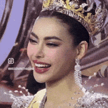 a woman wearing a crown and earrings smiles for the camera