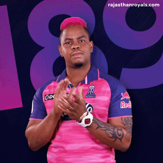 a man wearing a rajasthan royals jersey applauds
