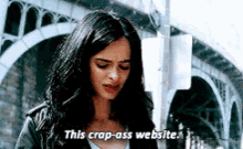 a woman in a leather jacket is standing in front of a bridge and says this crap-ass website .