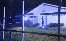 a man stands in front of a white building with a sign that says ' s.m. ' on it