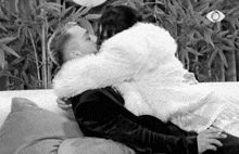 a black and white photo of a man and woman hugging and kissing