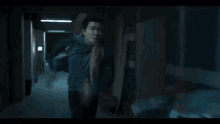 a man is running down a dark hallway .