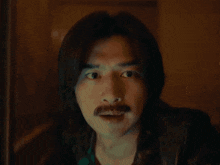 a man with a mustache gives a thumbs up