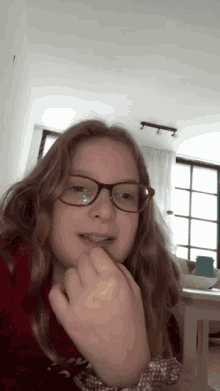 a young girl wearing glasses and a red sweater with the word christmas on it