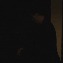 a shadow of a man is cast on a wall in a dark room