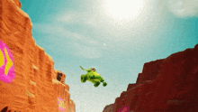 a green vehicle is flying through the air over a desert landscape