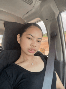 a young girl wearing a black shirt and a seat belt