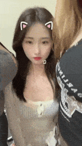 a woman with a cat ear sticker on her head is standing next to two other women .