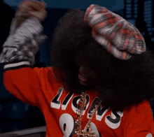 a person wearing a red shirt that says lions and a plaid hat
