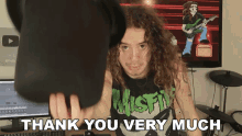 a man wearing a shirt that says misfits is holding a hat and saying thank you very much