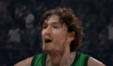 a basketball player wearing a green jersey with the number 16 on it