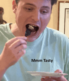 a man wearing a tshirt that says mmmm tasty is eating food